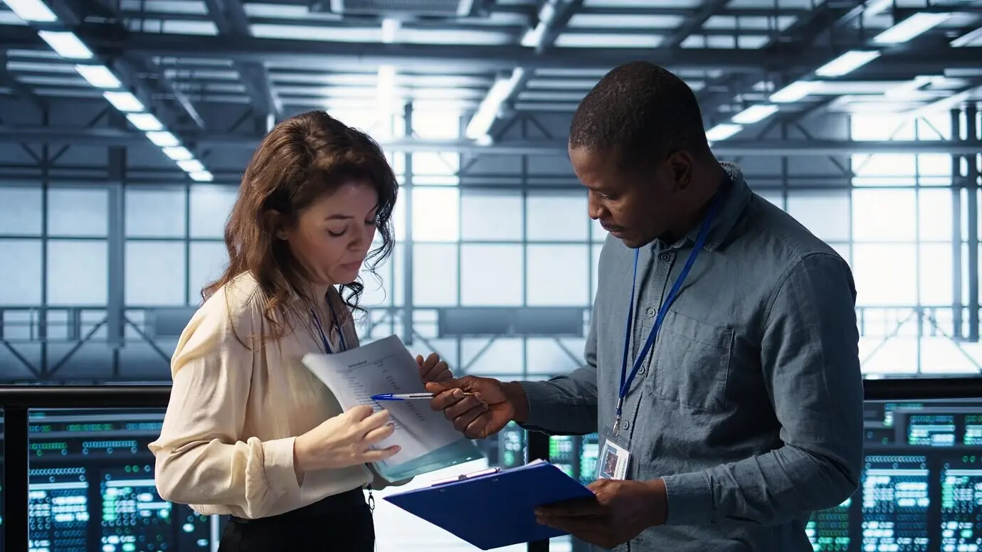 Команда руководителей центра обработки данных читает бумажные документы.